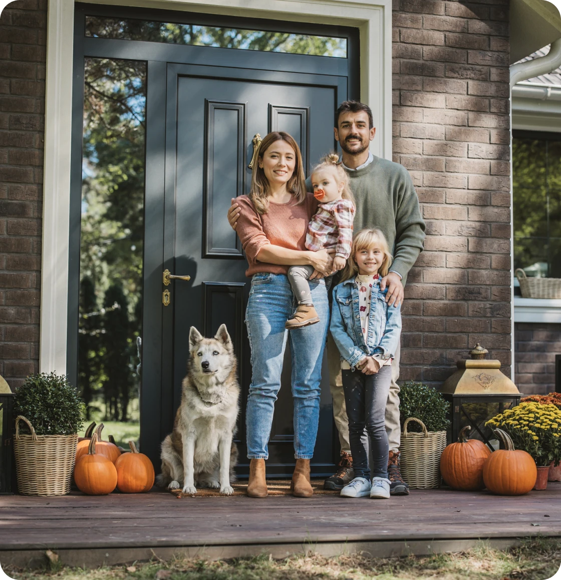 Happy family and dog outside house