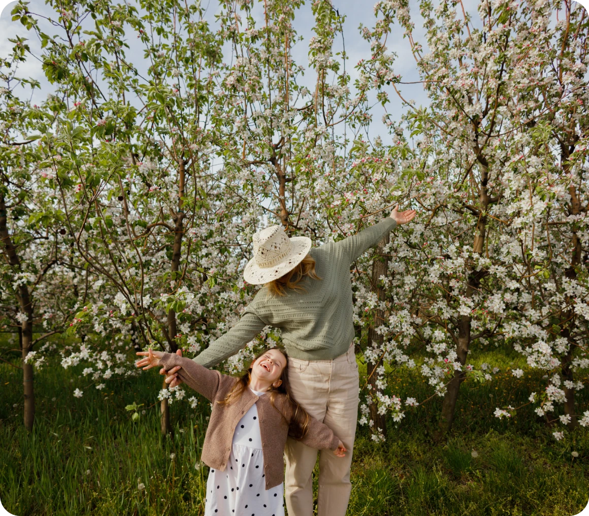 Woman and child in blooming fruit grove