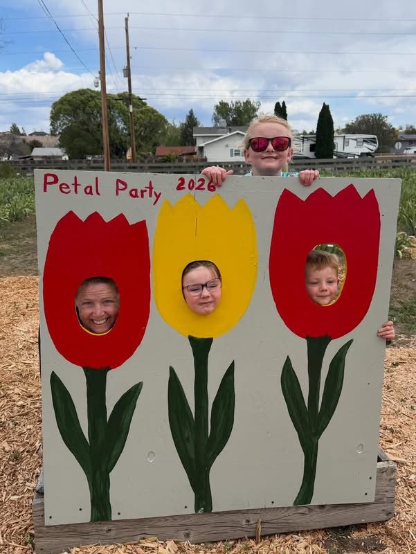 Four people peeking through tulip cutout board